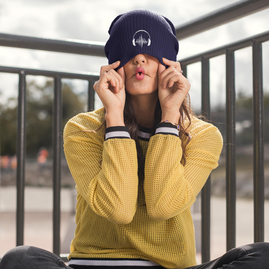 girl pulling funy facce wearing embroidered headphones beanie