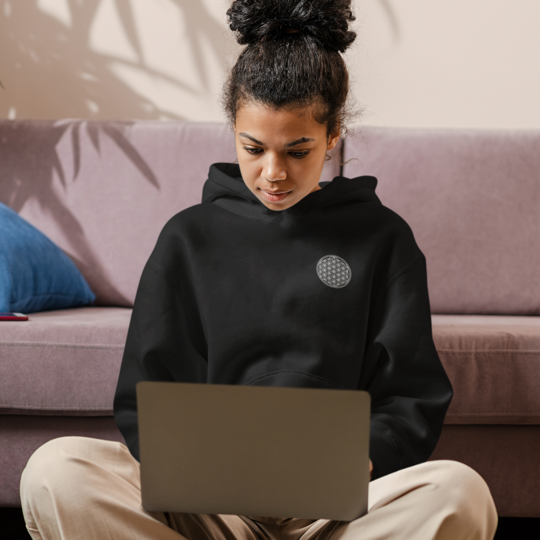 female digital nomad working remotely wearing flower of life black hoodie